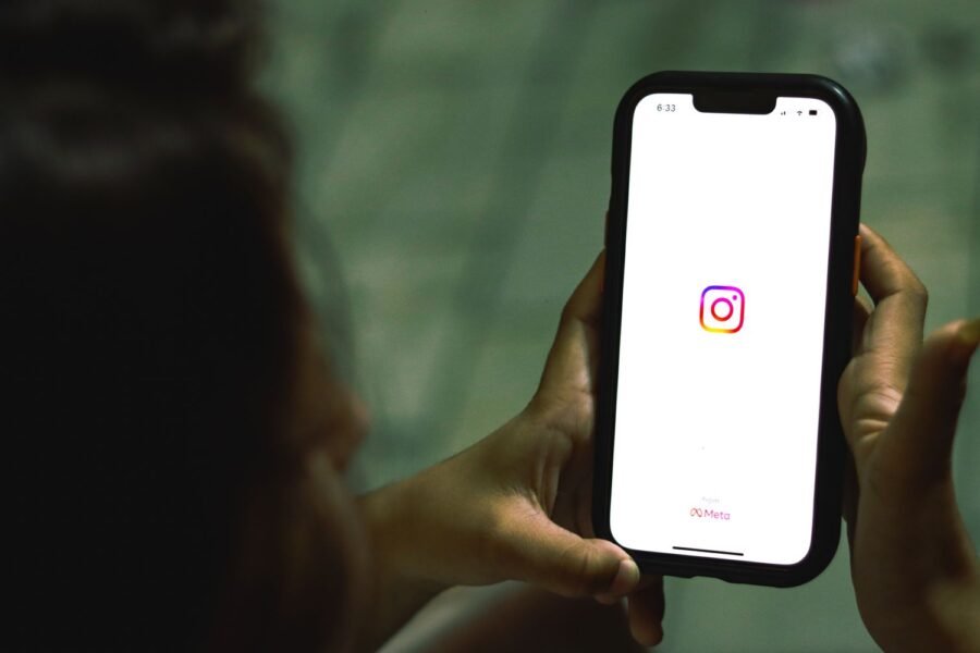 Mano sosteniendo un teléfono con una app de redes sociales, marketing para psicólogos