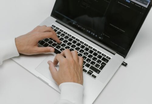 Manos escribiendo en un teclado de laptop, simbolizando protección de datos