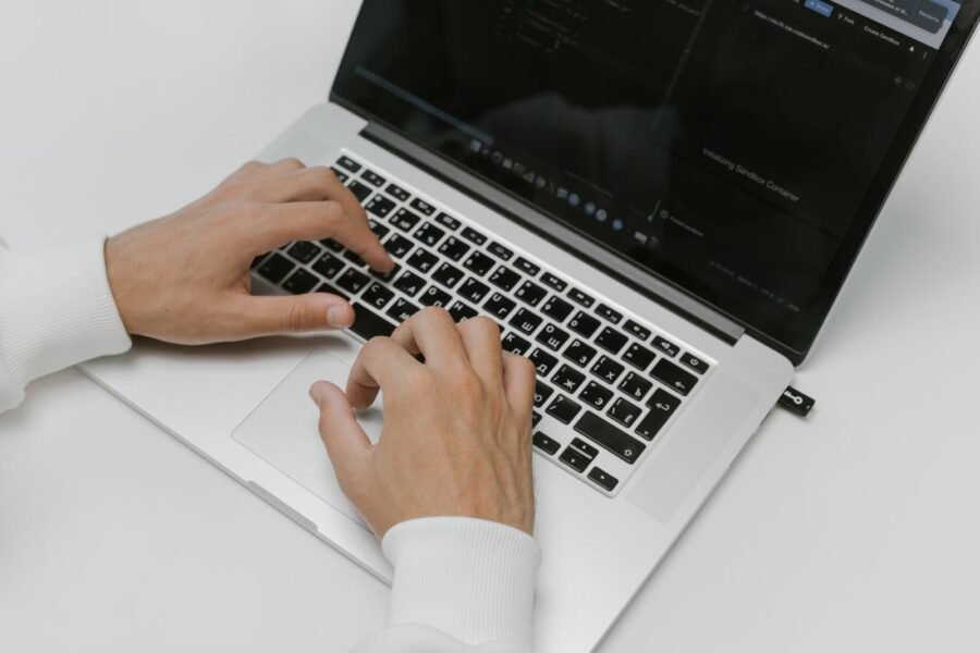 Manos escribiendo en un teclado de laptop, simbolizando protección de datos